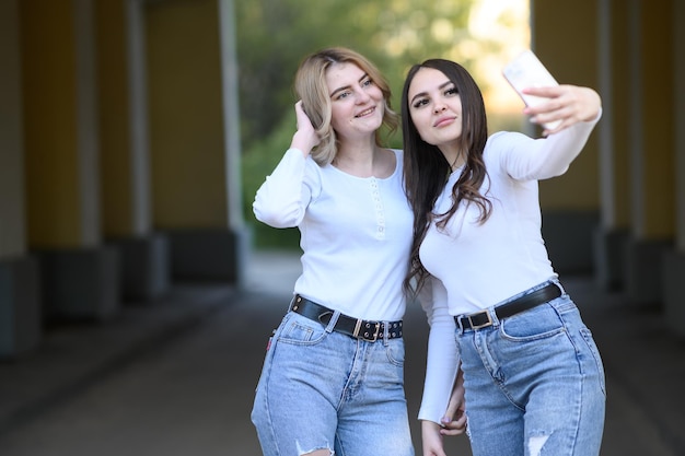 Jovens morenas e loiras tiram uma selfie na rua