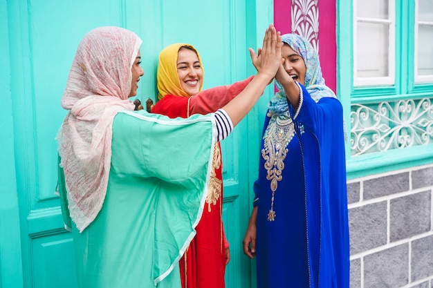 Jovens muçulmanas empilhando as mãos ao ar livre