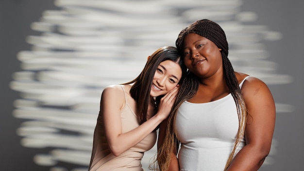 Foto jovens mulheres alegres abraçando imperfeições, criando campanha de cuidados com a pele na câmera, anunciando mensagem de empoderamento e amor próprio. diversas garotas promovendo feminilidade e produtos de beleza.