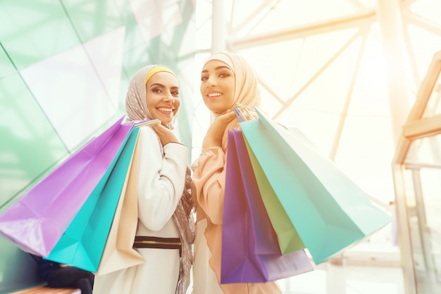 Jovens mulheres árabes com pacotes em pé