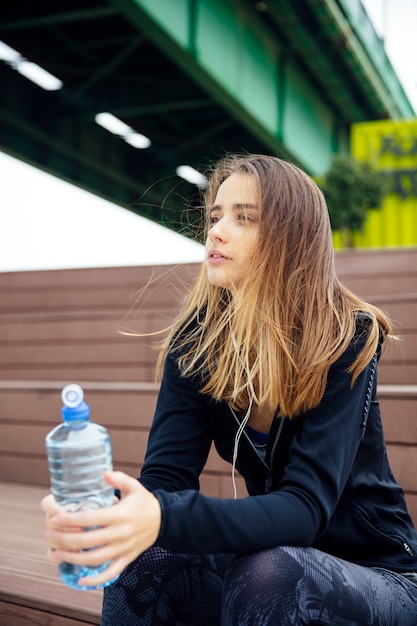 Jovens mulheres bonitas descansando e bebendo água depois de fazer exercícios