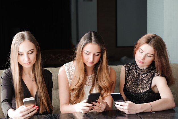 Jovens mulheres brancas usando telefone e dizendo não à vida. Conceito de dependência de smartphone.