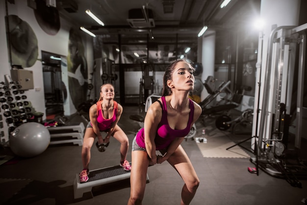 Jovens mulheres caucasianos exercitando na academia.