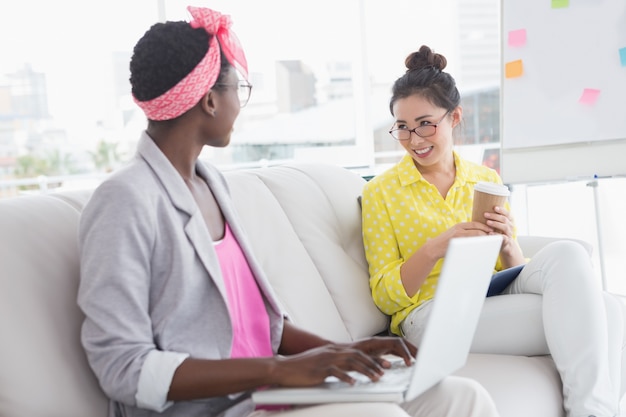 Jovens mulheres criativas conversando no sofá