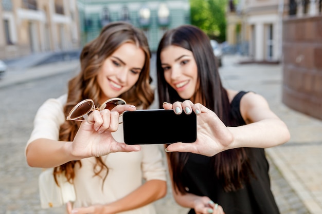 Jovens mulheres felizes com sacos de compras