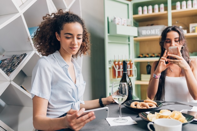 jovens mulheres interior bebendo depois do trabalho