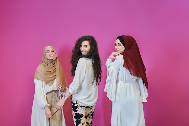 Jovens mulheres muçulmanas posando em fundo rosa. Duas meninas felizes e bonitas usando hijab representando o conceito de Ramadã