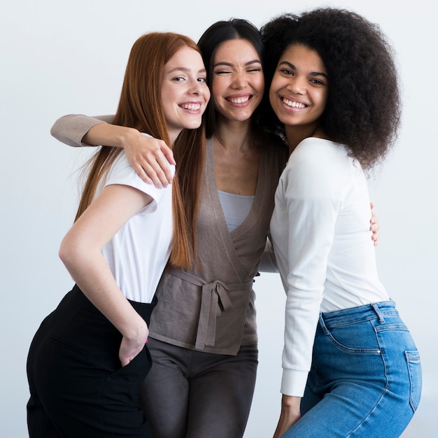 Jovens mulheres positivas que sorriem junto