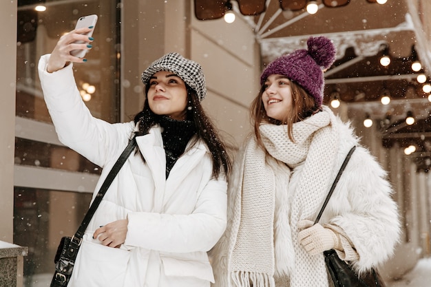 Jovens mulheres sorridentes com roupas quentes de inverno conversando