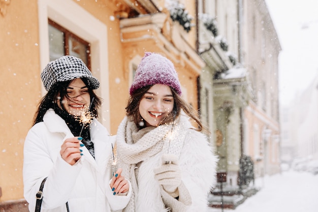 Jovens mulheres sorridentes com roupas quentes de inverno conversando