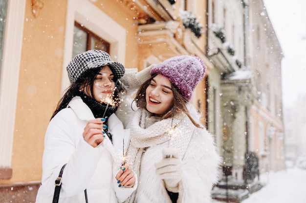 Jovens mulheres sorridentes com roupas quentes de inverno conversando