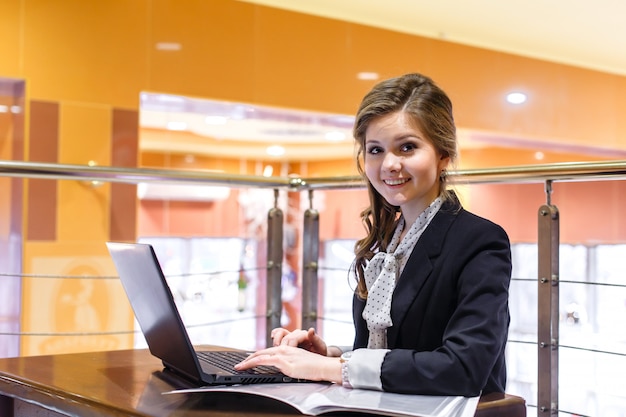 Jovens mulheres sorrindo sentado em um café e trabalhando em um laptop