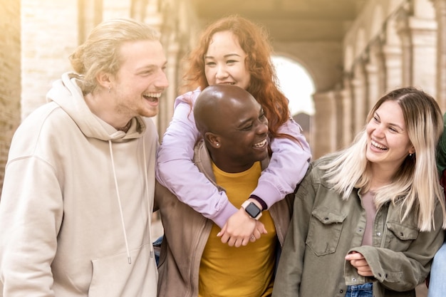 Foto jovens multirraciais andando alegremente na rua garotos e garotas se divertindo juntos