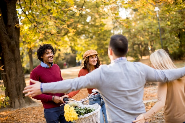 Jovens multirraciais caminhando no parque de outono e se divertindo