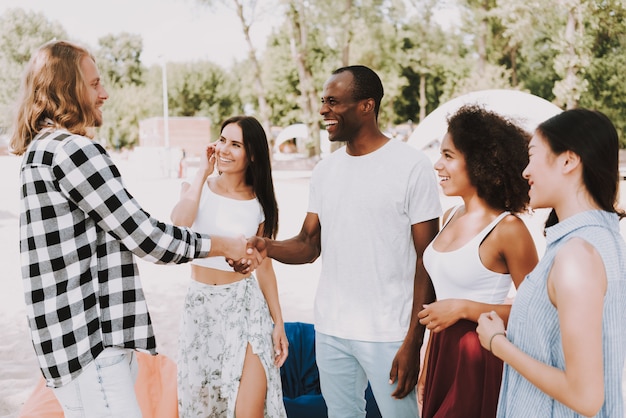 Jovens multirraciais encontram amigo Handshaking