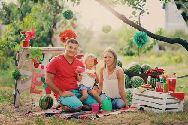 Foto jovens pais brincam com uma criança pequena no jardim em casa