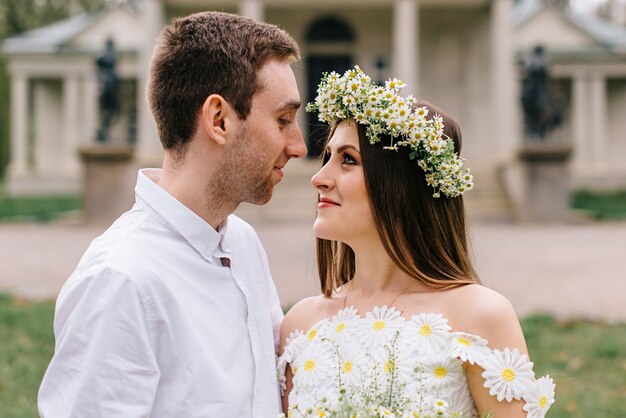 Jovens recém-casados felizes se abraçando em um parque na primavera, close-up