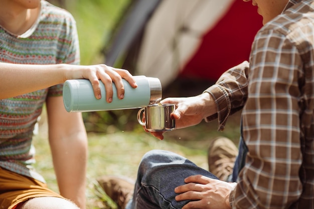 Jovens são aquecidos em uma fogueira e cozinham em um acampamento de verão