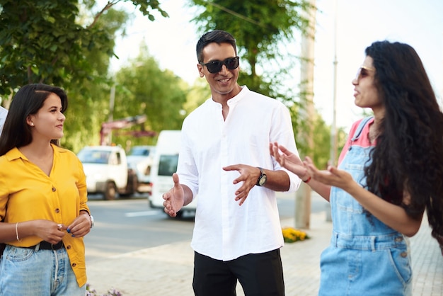 Jovens se divertindo ao ar livre. um grupo de amigos multiétnicos está conversando