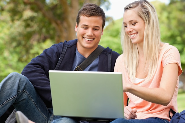 Jovens sentados ao usar um laptop