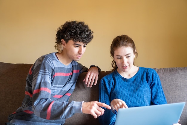 Jovens trabalhando em um laptop do sofá