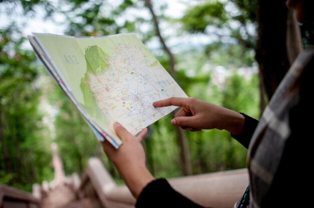 Jovens turistas e um mapa com um sorriso estão felizes em viajar para vários locais.