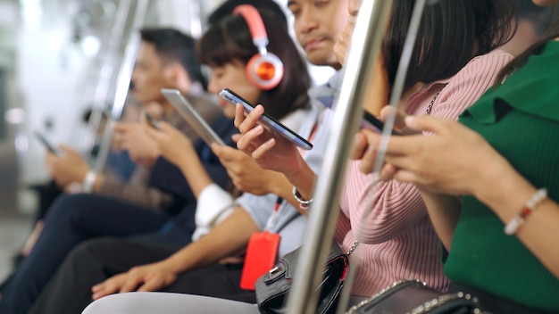 Jovens usando celular no metrô