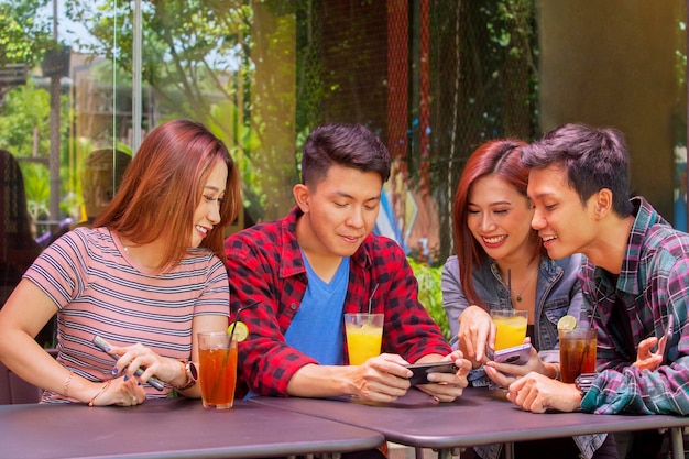 Jovens usando telefone celular e bate-papo no café