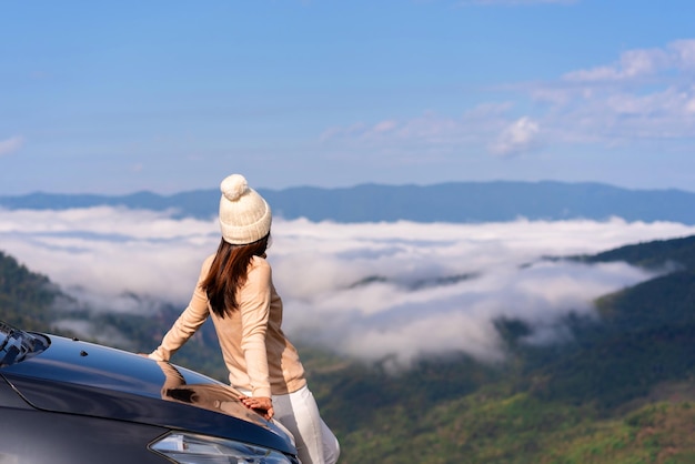 Jovens viajantes com carro assistindo um belo mar de neblina sobre a montanha enquanto viajam dirigindo viagem de férias