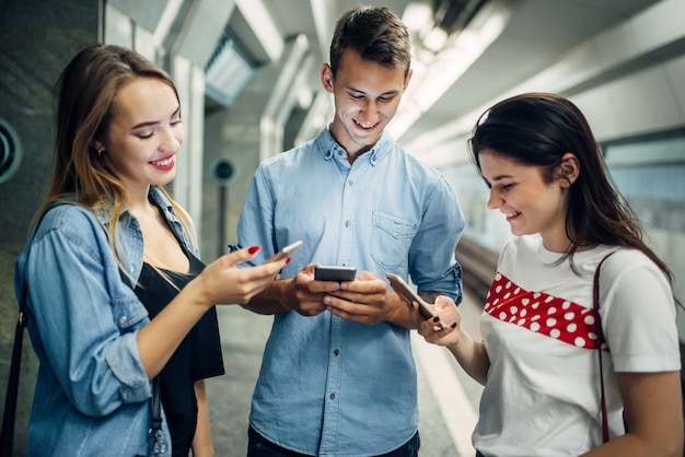 Jovens viciados em telefone usando gadgets no metrô, problemas com vícios, viciados em redes sociais, estilo de vida underground moderno