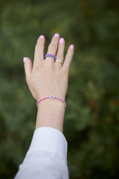 Joyas modernas con cuentas en la mano de la niña. Anillos y pulseras en la mano de la niña. multicolor