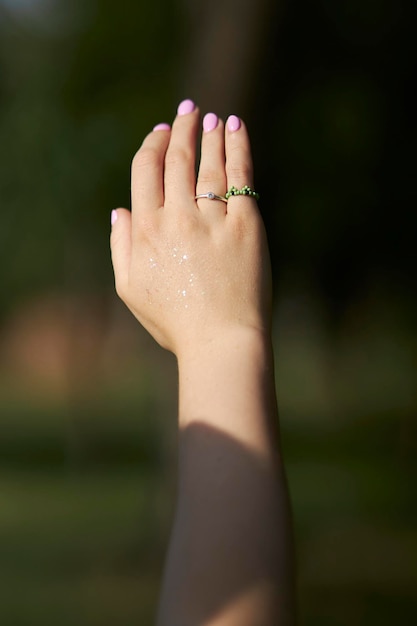 Joyas modernas con cuentas en la mano de la niña. Anillos y pulseras en la mano de la niña.