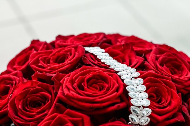 Joyas de piedras preciosas, moda nupcial y concepto de compras de lujo, pulsera de diamantes de lujo y ramo de rosas rojas, regalo de amor de joyería en el día de San Valentín y vacaciones románticas presentes