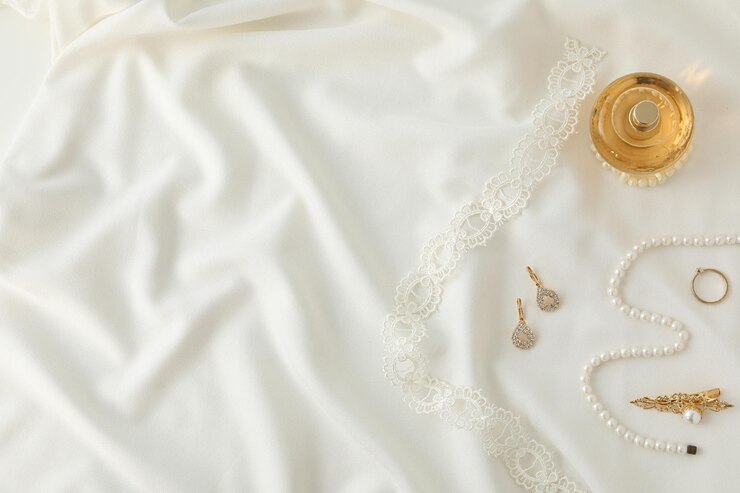 Joyería de boda y perfume sobre fondo blanco, espacio para texto