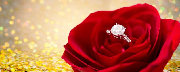 Foto joyería, romance, propuesta, día de san valentín y concepto de vacaciones - cierre del anillo de compromiso de diamantes en flor de rosa roja