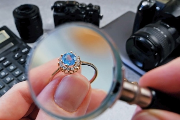 Foto joyero mirando anillo con piedra azul turmalina paraiba joyeros inspeccionar y verificar la casa de empeño