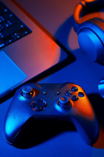Joystick de auriculares y teclado de computadora en la mesa negra