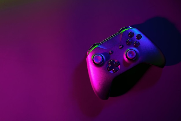Joystick de juego en fondo negro con luz de neón.