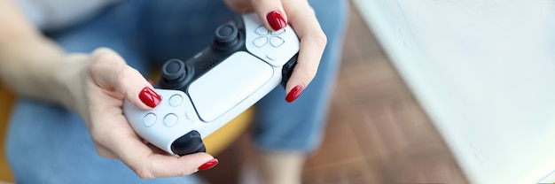 Foto joystick de juego de plata en primer plano de manos femeninas