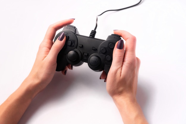 Joystick en manos femeninas sobre un fondo blanco, concepto de juego