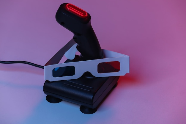 Joystick retro con gafas 3d en luz de neón azul rojo. Atributos de los 80