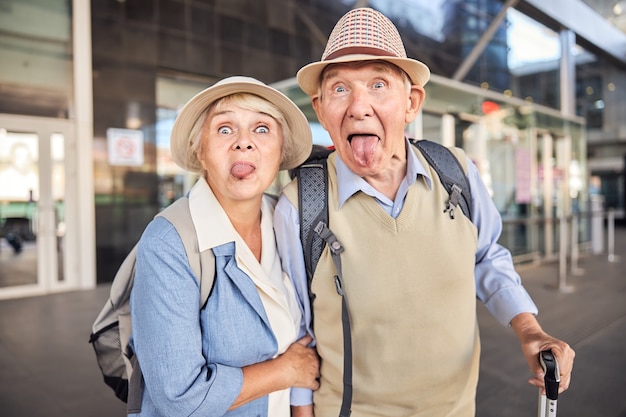 Un jubilado travieso y su esposa sacando la lengua frente a la cámara