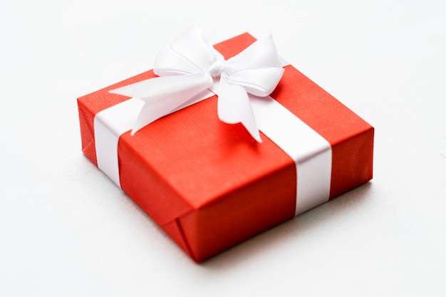 Jubiläumsgeschenk in einer roten Geschenkbox auf weißer Wand. Glückliches Beziehungskonzept