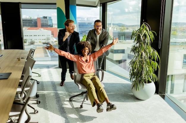 Jubilant Office Feiern fängt Kollegen Spontane Stuhlrennen im sonnigen Raum