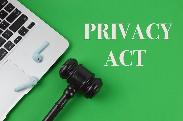 Judge gavel laptop y auriculares sobre fondo verde escrito con PRIVACY ACT