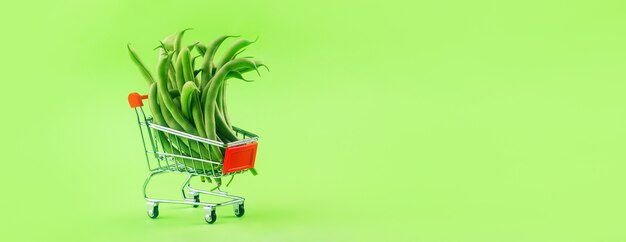 Judías verdes en un carrito de compras, comprando comida vegetariana