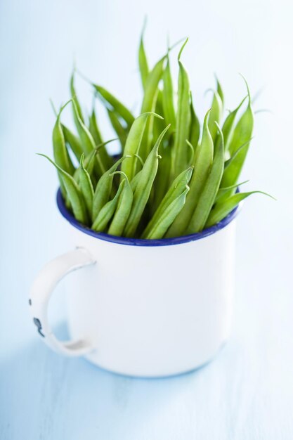 Judías verdes frescas en taza blanca