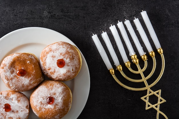 Jüdische Chanukka-Menora- und -sufganiyot-Schaumgummiringe auf Schwarzem