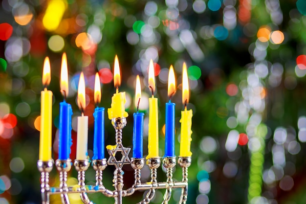 Jüdischer Feiertag Chanukka-Hintergrund mit traditionellen Kandelabern und brennenden Kerzen menorah