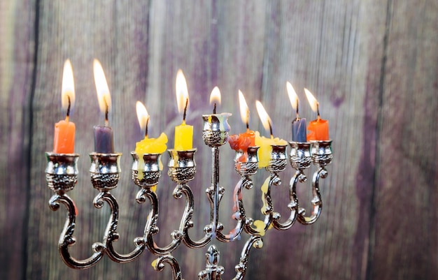 Jüdischer Feiertag Chanukka mit traditioneller Menorah und hölzernen Dreidels, die sich oben glänzen